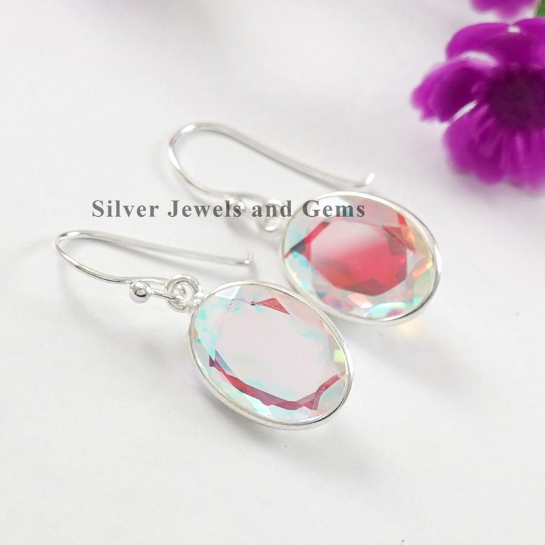Puede incluir: Un par de pendientes de plata con piedras preciosas iridiscentes de forma ovalada. Los pendientes tienen un dise&ntilde;o sencillo y son perfectos para el uso diario.