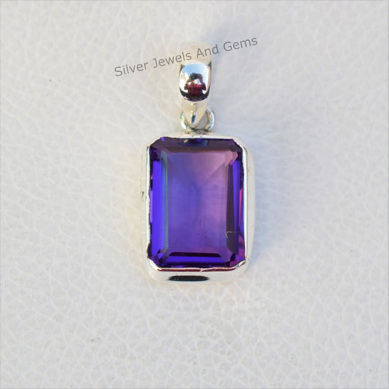 May include: A silver pendant featuring a large, rectangular, purple amethyst gemstone.
