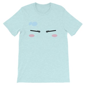 May include: A light blue t-shirt with a cartoon face printed on the front. The face has black eyebrows, black eyes, and pink cheeks.