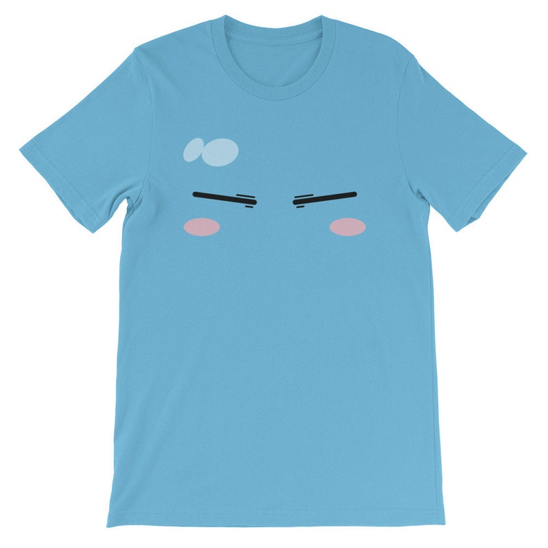 May include: A light blue t-shirt with a cartoon face printed on the front. The face has black eyebrows, pink cheeks, and a light blue sweat drop on the forehead.
