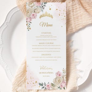 May include: A menu card with a floral design and gold accents. The menu includes starters, main courses, and desserts. The card is decorated with a gold tiara and the name "Victoria's Quincea&ntilde;era" with the date 10.15.202x.