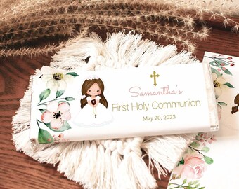 May include: White chocolate bar with a floral design and a girl in a white dress. The text on the bar reads "Samantha's First Holy Communion May 20, 2023".