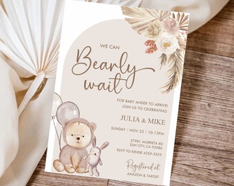 Könnte beinhalten: Eine Babyparty-Einladung mit beigefarbenem Hintergrund und einer niedlichen Illustration eines Teddybären, der Ballons hält. Der Text lautet "We can Bearly wait" und enthält Details zur Veranstaltung, einschließlich Datum, Uhrzeit und Ort. Die Einladung enthält auch den Text "Registered at Amazon & Target".