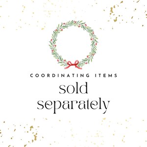 May include: A green wreath with red berries and a red bow. The text "COORDINATING ITEMS sold separately" is below the wreath.