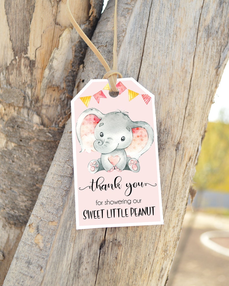 Op de afbeelding: Roze bedankkaartje met een schattig grijs olifantje dat een roze hartje vasthoudt. Het kaartje heeft de tekst "Bedankt voor het verwennen van onze lieve kleine pinda".