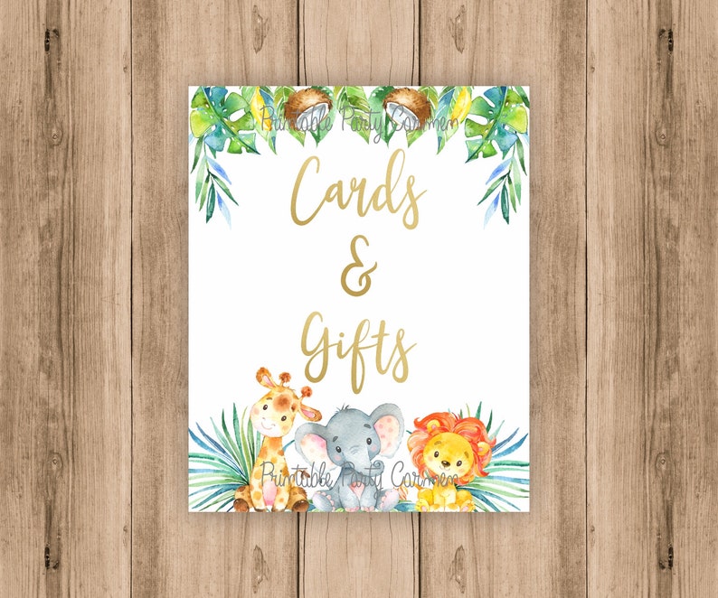 K&ouml;nnte beinhalten: Ein wei&szlig;es Schild mit goldener Schrift, auf dem "Cards & Gifts" steht. Das Schild ist mit gr&uuml;nen Bl&auml;ttern, Kokosn&uuml;ssen und einer Giraffe, einem Elefanten und einem L&ouml;wen verziert.