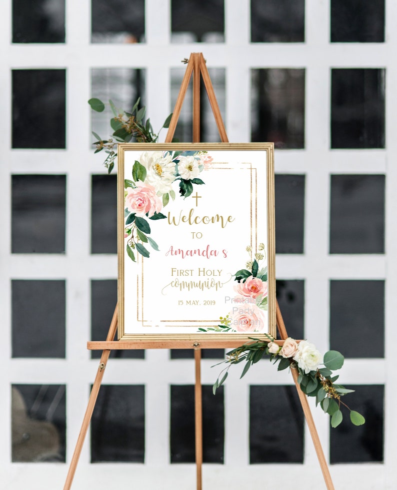 Pode incluir: Bem-vindo &agrave; Primeira Comunh&atilde;o de Amanda, sinal com moldura dourada e design floral. O sinal est&aacute; em um cavalete de madeira e tem um fundo branco com flores rosa e brancas. A data &eacute; 15 de maio de 2019.