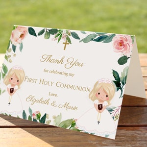 May include: Thank you card with a floral design and two illustrations of girls in white dresses. The text reads "Thank You for celebrating my First Holy Communion. Love, Elizabeth & Marie."