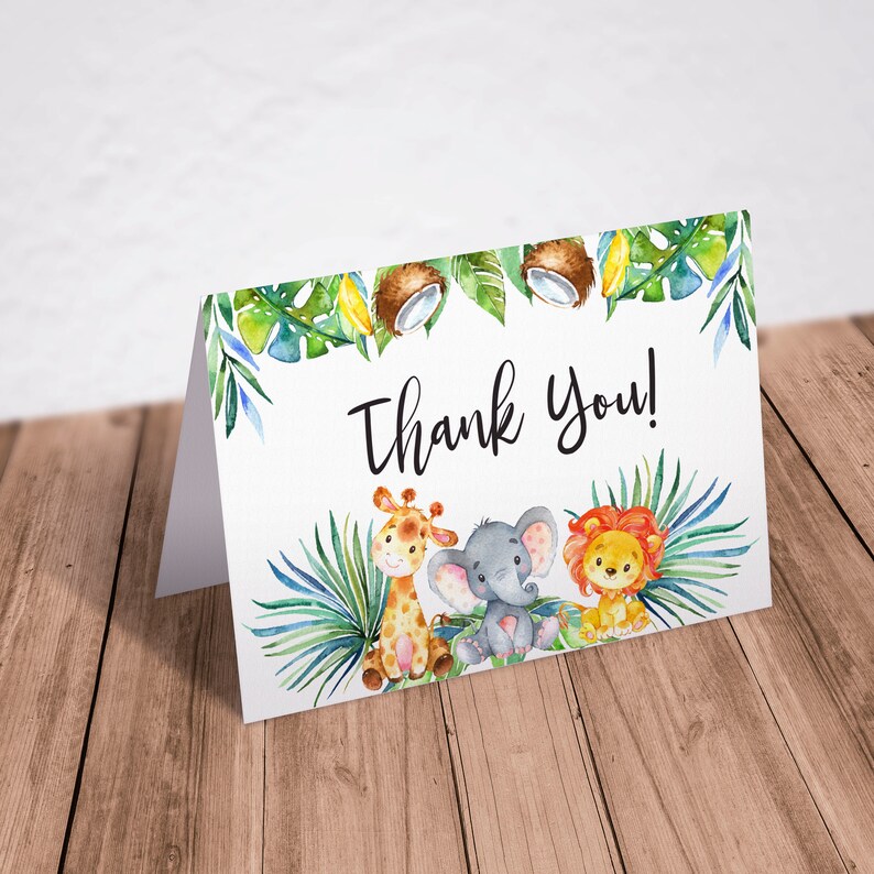 Może przedstawiać: Kartka z podziękowaniem z akwarelową ilustracją żyrafy, słonia i lwa otoczonych zielonymi liśćmi i kokosami. Tekst "Thank You!" jest napisany czarnym kolorem.