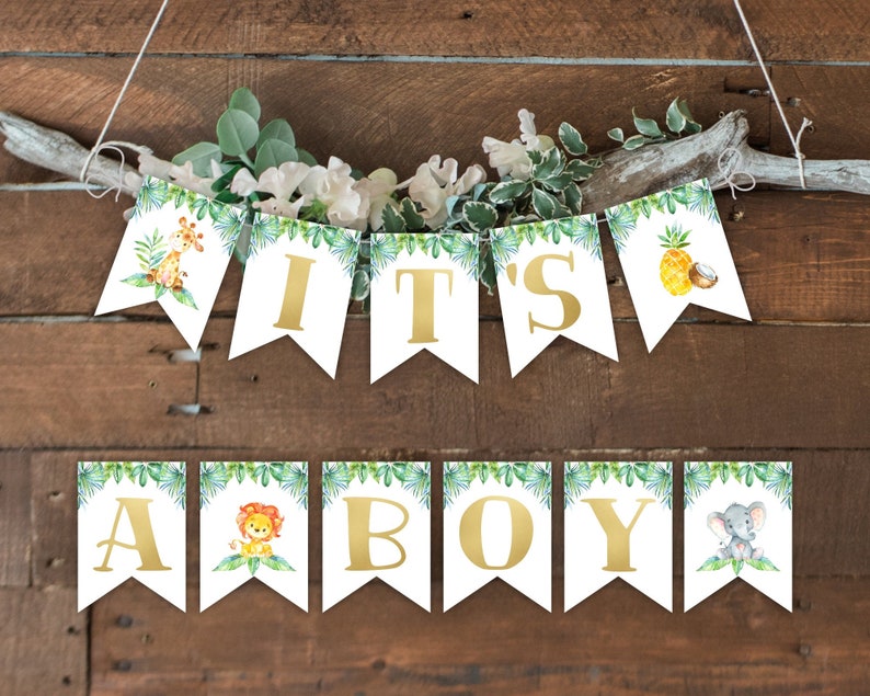 K&ouml;nnte beinhalten: Ein wei&szlig;es Banner mit gr&uuml;nen Bl&auml;ttern und goldenen Buchstaben, auf dem "It's a Boy" steht. Das Banner zeigt Illustrationen einer Giraffe, eines L&ouml;wen, einer Ananas und eines Elefanten.