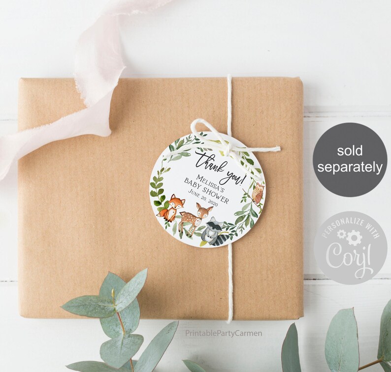 May include: Round thank you tag with a woodland theme. The tag features a wreath of green leaves with a fox, deer, and raccoon inside. The text reads "Thank you! Melissa's Baby Shower June 20, 2020".