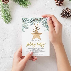 May include: A white invitation card with a gold glitter font. The card features a watercolor illustration of a pine branch with a gold star ornament hanging from it. The text on the card reads "Please join us for a Holiday Party" and includes the date, time, location, and RSVP information.