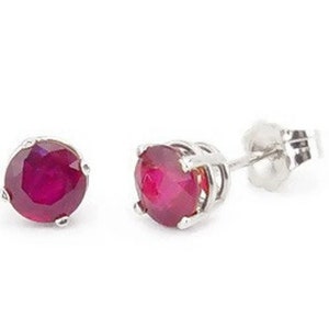 May include: A pair of silver stud earrings with round, red ruby gemstones.