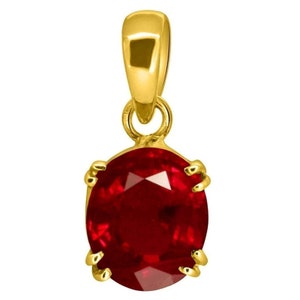 May include: A gold pendant with a red ruby gemstone. The pendant is oval shaped and has a simple design.