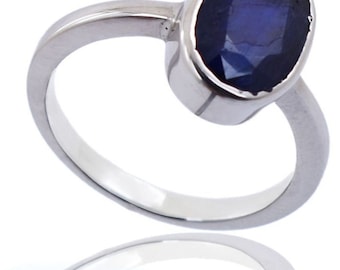 May include: A silver ring with a dark blue oval gemstone.