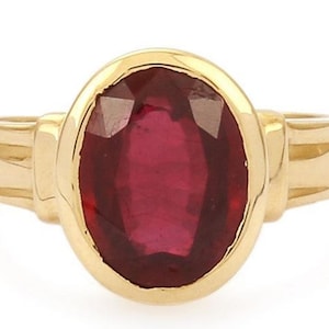 May include: A gold ring with a large oval-shaped ruby gemstone.
