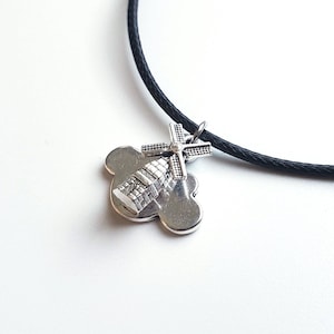 May include: A silver charm necklace with a black cord. The charm is a windmill on a cloud.