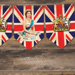 May include: A banner with five flags featuring the Union Jack design. Each flag has a portrait of Queen Elizabeth II and the text "1926 - 2022".