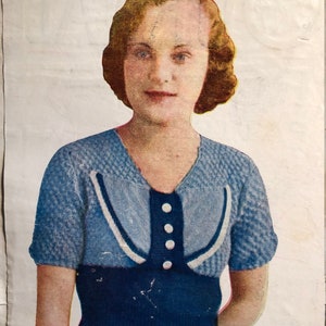 May include: A blue and white knitted sweater with a button-up front and short sleeves.