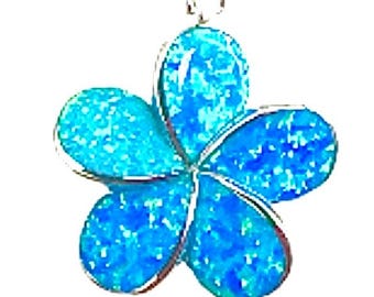 May include: A silver pendant in the shape of a flower with five petals. The petals are a bright blue with a textured finish, suspended from a silver chain. The jewellery is set against a white backdrop.
