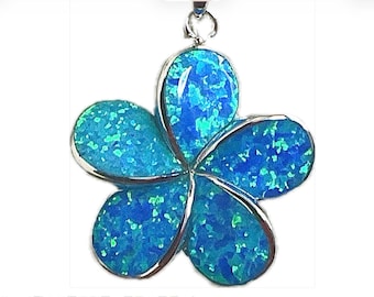 May include: A silver pendant in the shape of a flower with five petals. Each petal is filled with a vibrant blue opal-like material, with flecks of lighter blue and green. The pendant hangs from a silver loop.