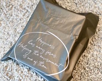 May include: A gray plastic mailing bag with a white circle and text that reads "Happiness has many forms. Helping the environment is one of them."
