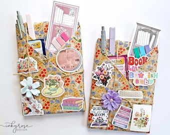 May include: Two floral fabric book pockets with decorative stickers, pens, and bookmarks. One pocket has a sticker that says "Just one more chapter." The other has a sticker that says "Reading helps your mind bloom."