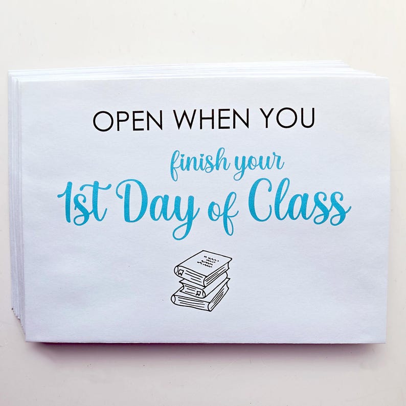 May include: A stack of white rectangular envelopes featuring the black text OPEN WHEN YOU and the blue script text finish your 1st Day of Class, accompanied by a small black line drawing of a stack of three books centered at the bottom.