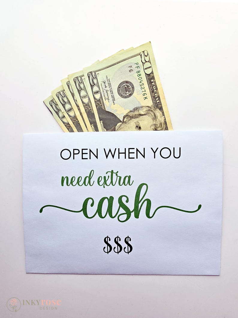May include: A white paper envelope containing several twenty-dollar bills. The envelope features the black text "OPEN WHEN YOU" followed by the green cursive text "need extra cash" and three black dollar signs at the bottom center.