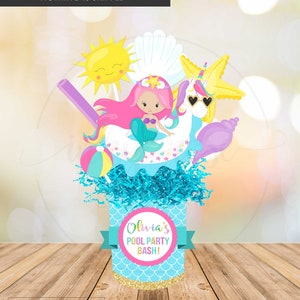 Może przedstawiać: Drukowana ozdoba centralna na przyjęcie przy basenie. Ozdoba przedstawia syrenkę, jednorożca, muszlę, piłkę plażową, słońce i słomkę. Ozdoba jest ozdobiona w niebiesko-różowej kolorystyce i zawiera napis "Olivia's Pool Party Bash!"