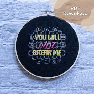 Può includere: Un telaio da ricamo circolare contenente tessuto nero con un disegno a punto croce. Il testo recita "YOU WILL NOT BREAK ME" in giallo e rosa. Attorno al testo ci sono piccole icone ricamate in bianco con un motivo esagonale. Testo PDF Download.