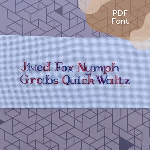 Pode incluir: Um tecido branco com as palavras "Jived Fox Nymph Grabs Quick Waltz" bordadas em fio vermelho e azul.