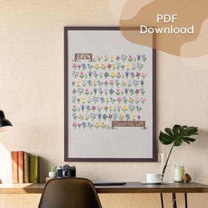 Peut inclure: Un motif de point de croix encadré représentant un champ de fleurs colorées avec le texte "2024" et "Seattle WA".