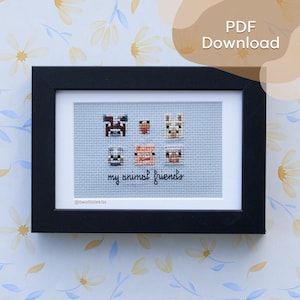 May include: A framed cross-stitch featuring six cartoon animal faces on a light blue background. The phrase "my animal friends" is stitched below the animals. The frame is black, and the background is a floral pattern.