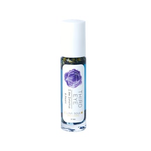 May include: A blue and purple roller bottle with the text "THIRD EYE" and "I Am Intuitive & Aware" on the label. The bottle is labeled "LUNA SOUL WELLNESS" and contains 10 ml of liquid.