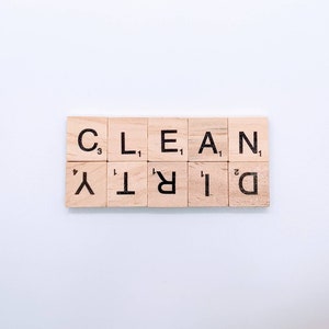 May include: Wooden letter tiles spelling out the words "CLEAN" and "DIRTY" on a white background.