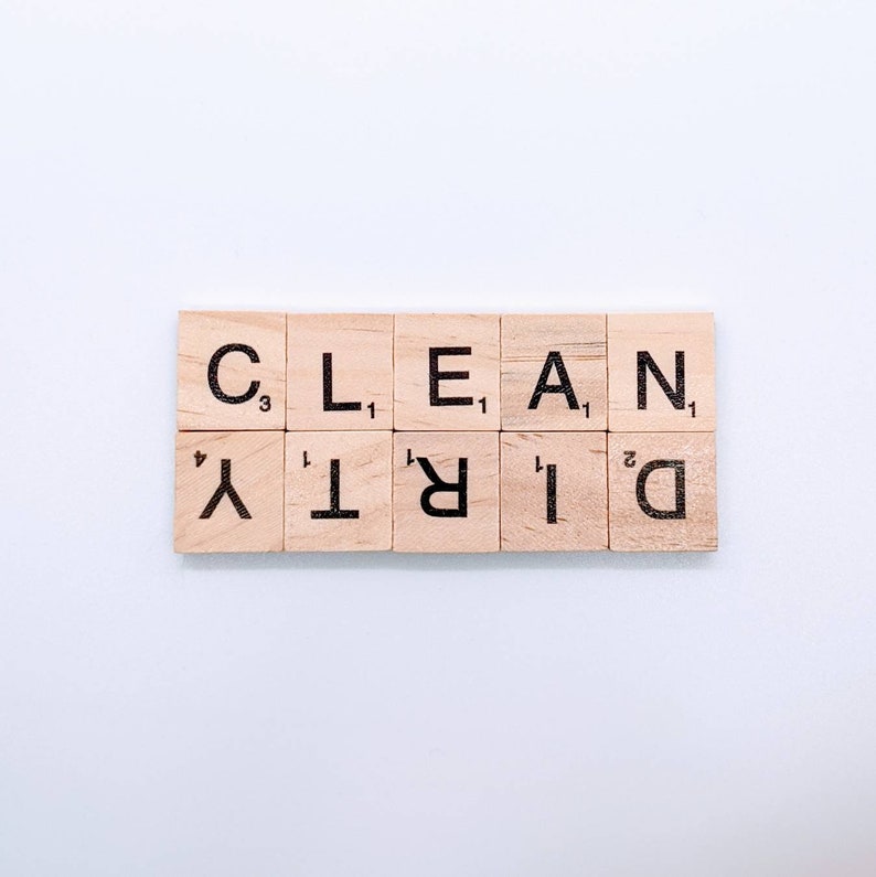 May include: Wooden letter tiles spelling out the words "CLEAN" and "DIRTY" on a white background.