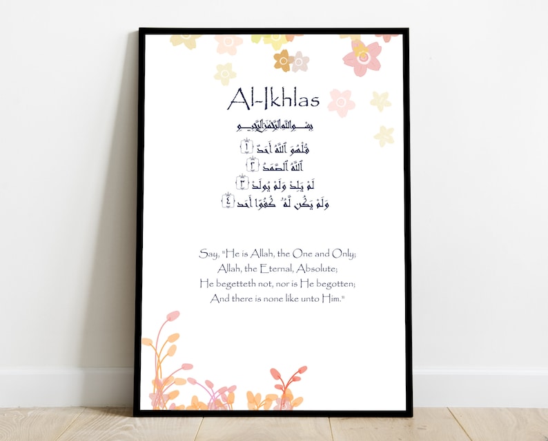 May include: A printable Islamic art print with a black frame and a white background. The print features the Arabic text of the Al-Ikhlas Surah, also known as the Purity Chapter, from the Quran. The text is in blue and is surrounded by a floral design in shades of pink, orange, and yellow. The English translation of the Surah is printed below the Arabic text.