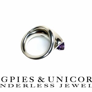 May include: A silver ring with a unique, curved design, featuring a triangular, deep purple gemstone. The ring is set against a white background. The text "MAGPIES & UNICORNS GENDERLESS JEWELRY" is at the bottom.