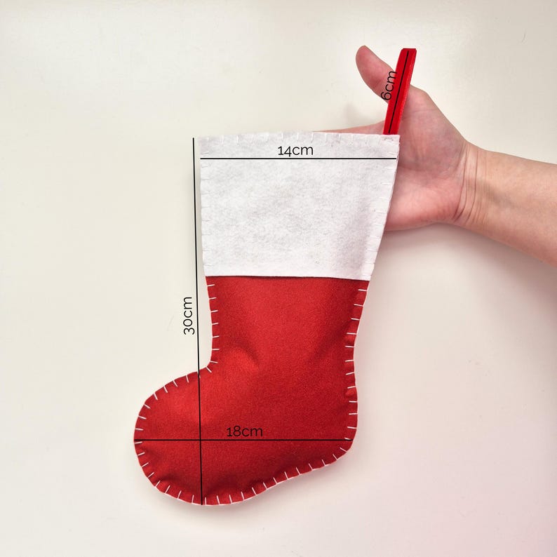 May include: A red and white felt Christmas stocking with a 6-inch loop at the top. The stocking measures 14 inches wide, 18 inches long, and 30 inches tall.