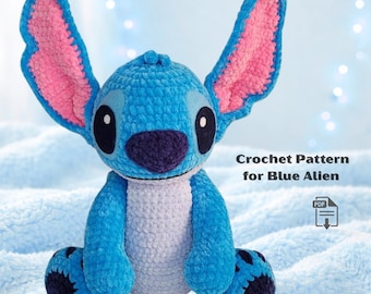 May include: A blue crocheted alien plush toy with large ears, a purple nose, and black eyes. The text "Crochet Pattern for Blue Alien" is visible. The toy is sitting on a light blue, textured surface.