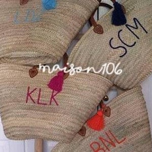 May include: Four straw tote bags with leather handles and colorful tassels. Each bag has a different name embroidered on the front: KKL, BNL, SCM, and "I Love".