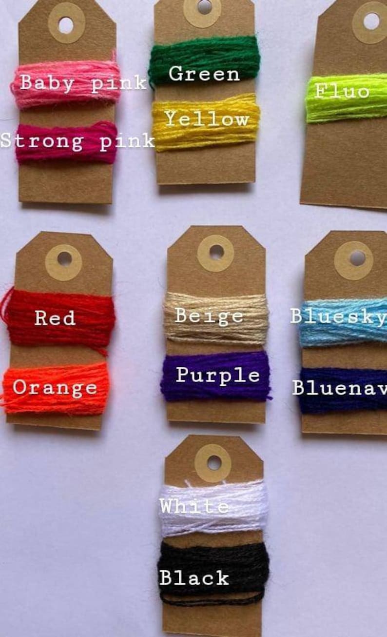May include: A collection of yarn samples on brown card stock tags. The yarn colors include baby pink, strong pink, green, yellow, fluo, red, orange, beige, bluesky, bluenav, white, and black.