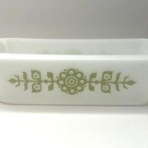Puede incluir: Fuente rectangular blanca con bordes redondeados. Presenta un diseño floral en verde oliva. El diseño es simétrico y está centrado en la parte frontal de la fuente.