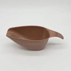 May include: A light brown, vintage-style gravy boat with a curved handle. The boat has a wide, shallow bowl and a spout for easy pouring. The handle curves upward, providing a comfortable grip. The gravy boat is made of a smooth, solid material.