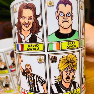 Peut inclure: Une tasse en c&eacute;ramique blanche avec des illustrations de joueurs de football en dessin anim&eacute;. La tasse pr&eacute;sente des images de David Ginola, Shay Given, Alan Shearer et Chris Waddle. Chaque joueur est repr&eacute;sent&eacute; dans un style de dessin anim&eacute; avec son nom et l'embl&egrave;me de son &eacute;quipe.