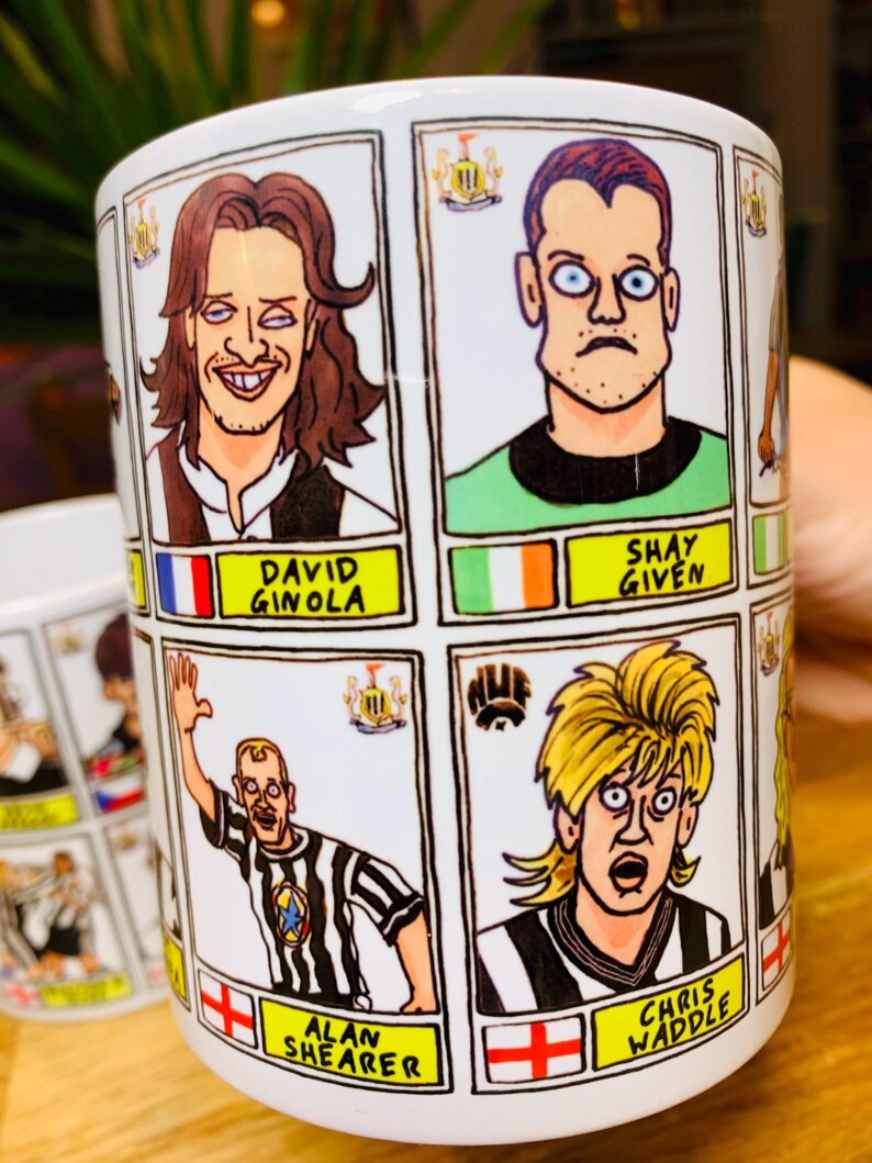 Peut inclure: Une tasse en c&eacute;ramique blanche avec des illustrations de joueurs de football en dessin anim&eacute;. La tasse pr&eacute;sente des images de David Ginola, Shay Given, Alan Shearer et Chris Waddle. Chaque joueur est repr&eacute;sent&eacute; dans un style de dessin anim&eacute; avec son nom et l'embl&egrave;me de son &eacute;quipe.