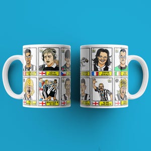 Peut inclure: Deux tasses blanches avec des poign&eacute;es noires. Chaque tasse pr&eacute;sente une grille d'images de joueurs de football en dessin anim&eacute; avec leurs noms et leurs affiliations d'&eacute;quipe. Les tasses sont sur un fond bleu.