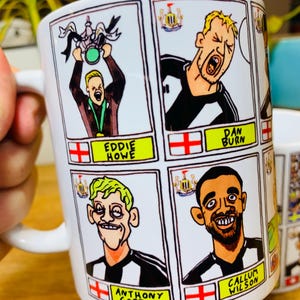 Puede incluir: Taza de cer&aacute;mica blanca con ilustraciones de dibujos animados de jugadores de f&uacute;tbol y el texto "Eddie Howe", "Dan Burn", "Anthony Gordon" y "Callum Wilson".