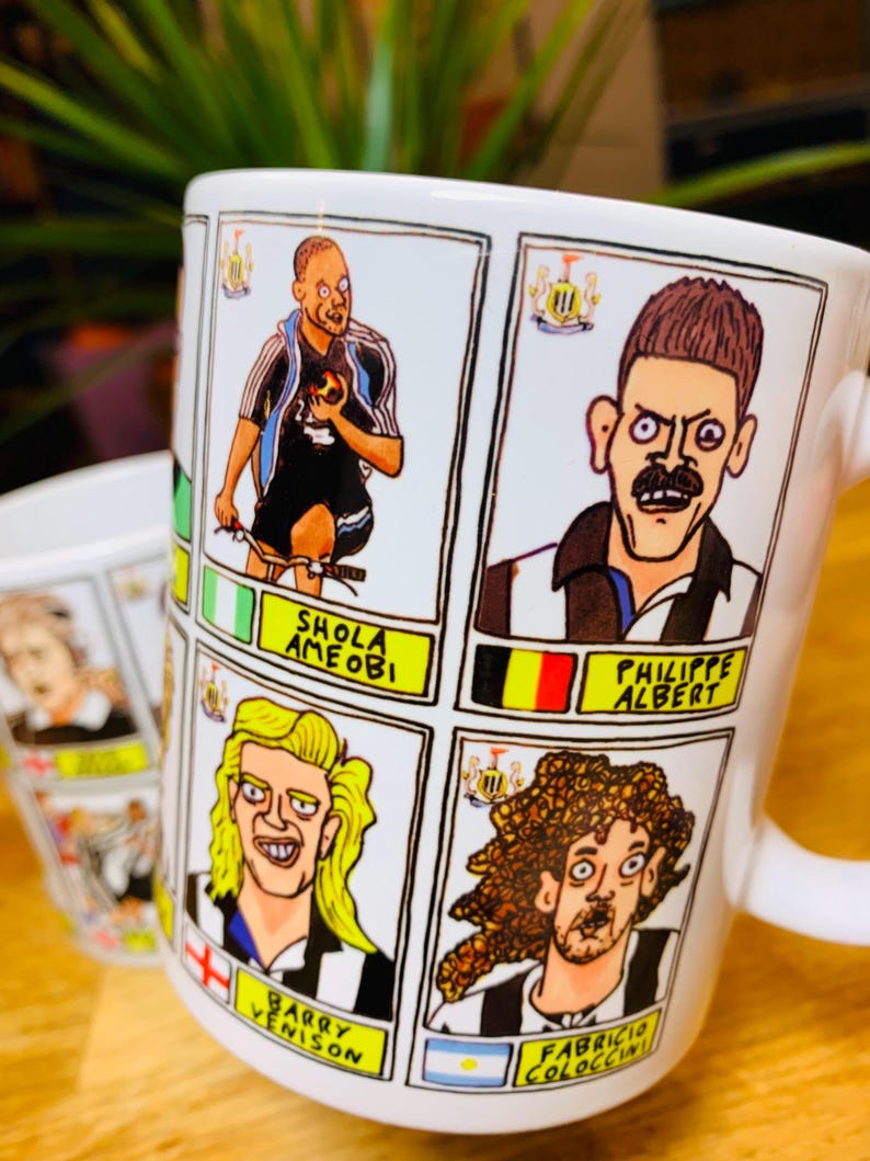 Peut inclure: Une tasse en c&eacute;ramique blanche avec une illustration de joueurs de football en dessin anim&eacute;. La tasse pr&eacute;sente les noms "Shola Ameobi", "Barry Venison", "Philippe Albert" et "Fabricio Coloccini".